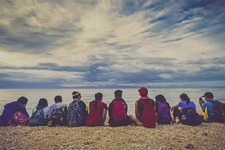 a group of people sitting on the beach